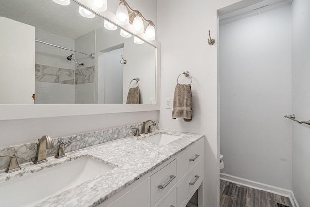 bathroom featuring toilet, baseboards, a sink, and wood finished floors