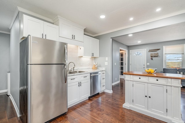 kitchen featuring dark wood-style floors, appliances with stainless steel finishes, white cabinets, and a sink