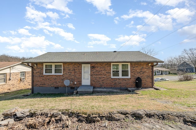 view of front of property with crawl space, brick siding, a front lawn, and roof with shingles