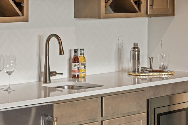 bar with tasteful backsplash, stainless steel microwave, a sink, and a dry bar