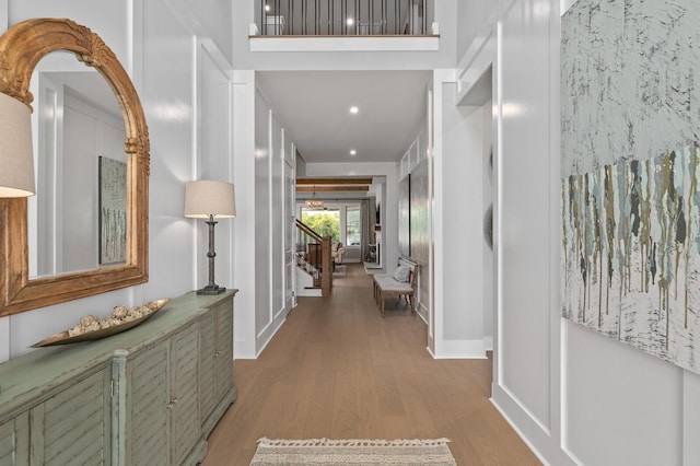 corridor featuring recessed lighting, stairs, and wood finished floors