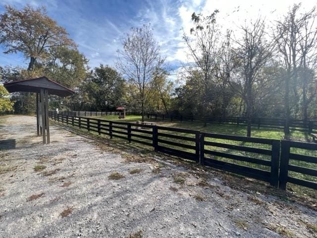 view of gate featuring a rural view and fence