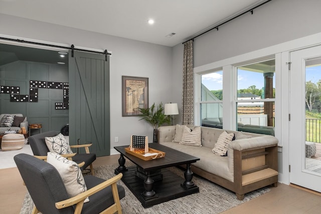 living room with visible vents, recessed lighting, and wood finished floors