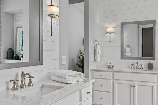 bathroom with vanity and wooden walls