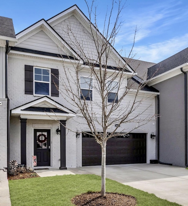 view of front of house featuring driveway, a shingled roof, an attached garage, and brick siding