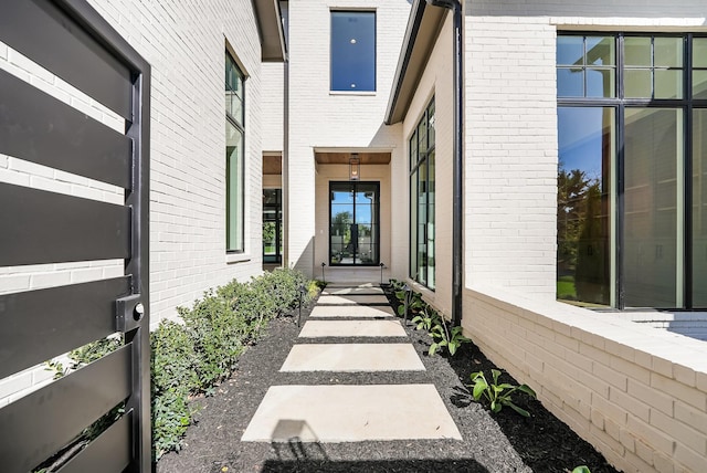 view of exterior entry featuring brick siding