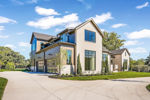 view of front of house featuring a front yard, concrete driveway, fence, and an attached garage