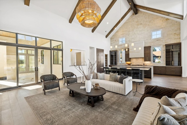 living area with high vaulted ceiling, wood finished floors, and beamed ceiling