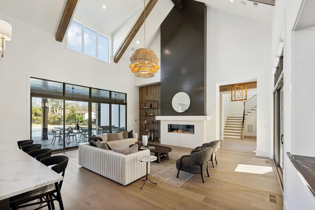 living area with plenty of natural light, a fireplace, wood finished floors, and beam ceiling