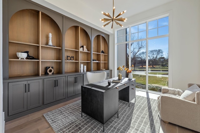 home office featuring a notable chandelier and wood finished floors