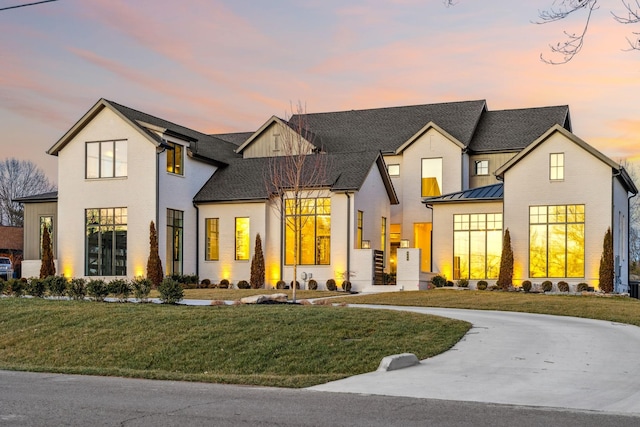 modern farmhouse style home with brick siding, a lawn, board and batten siding, a standing seam roof, and metal roof