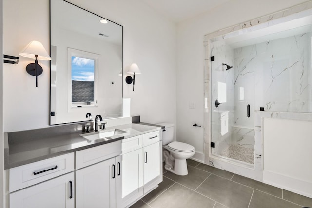 bathroom featuring tile patterned flooring, toilet, visible vents, vanity, and a marble finish shower