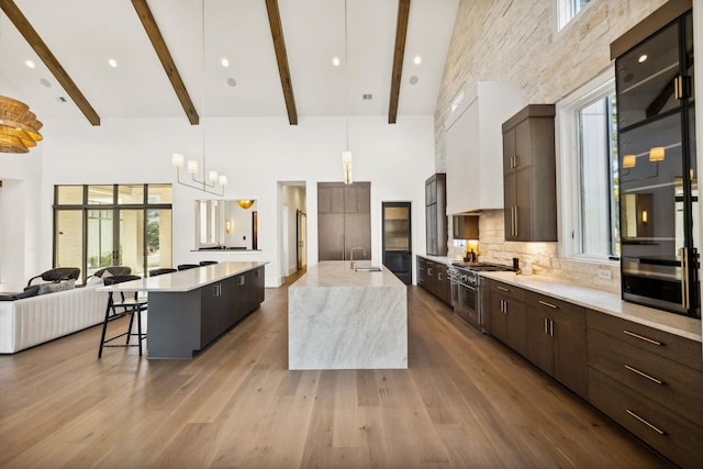 kitchen featuring a large island, tasteful backsplash, modern cabinets, high vaulted ceiling, and double oven range