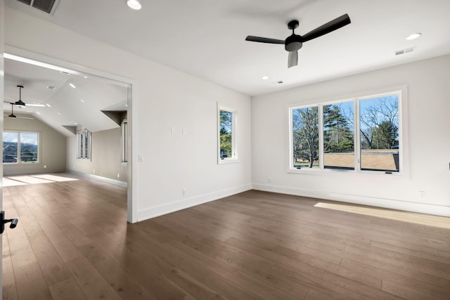 spare room featuring dark wood-style floors, a wealth of natural light, visible vents, and ceiling fan