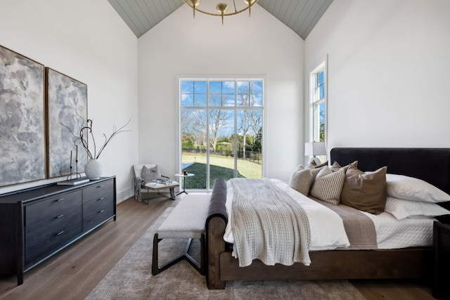 bedroom featuring high vaulted ceiling and wood finished floors