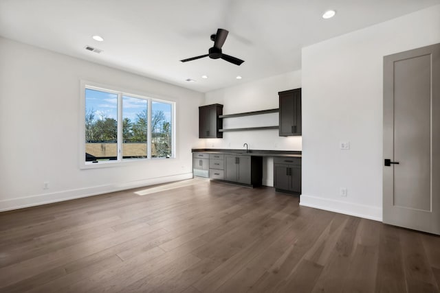 unfurnished living room with dark wood-style flooring, recessed lighting, visible vents, and baseboards