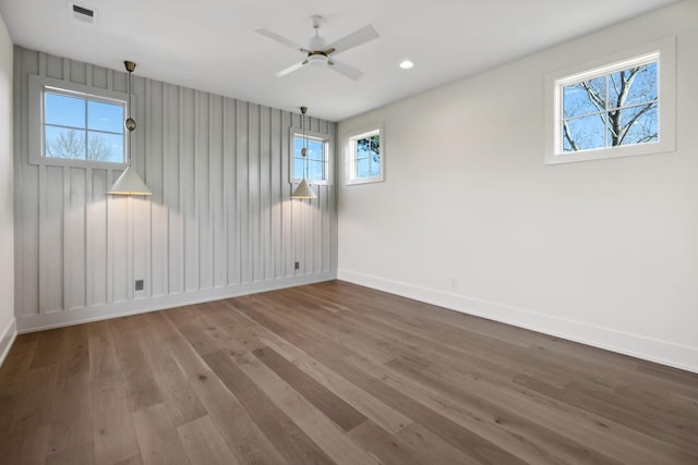 unfurnished room with recessed lighting, wood finished floors, a ceiling fan, visible vents, and baseboards