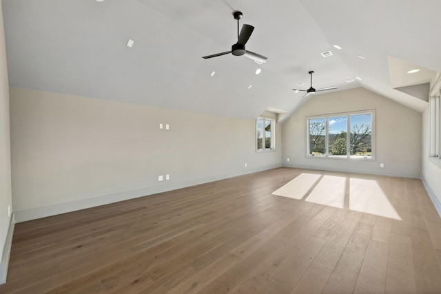 interior space featuring lofted ceiling, visible vents, ceiling fan, light wood-type flooring, and baseboards