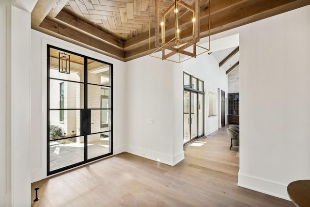 spare room featuring high vaulted ceiling, wood ceiling, baseboards, and wood finished floors