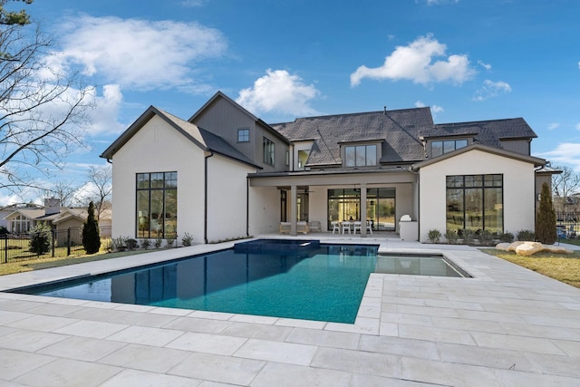 rear view of house with a fenced in pool, fence, and a patio