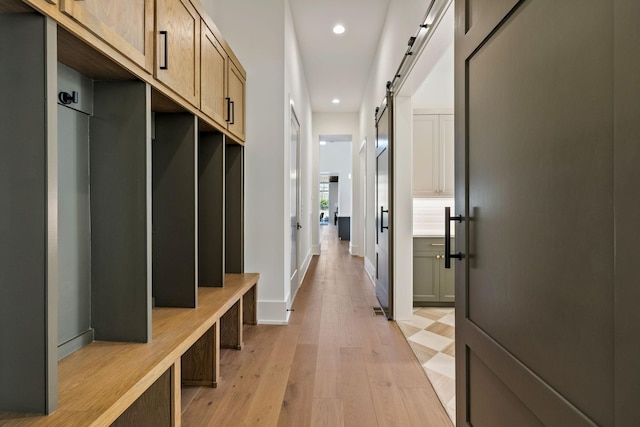 mudroom with baseboards, a barn door, light wood-type flooring, and recessed lighting