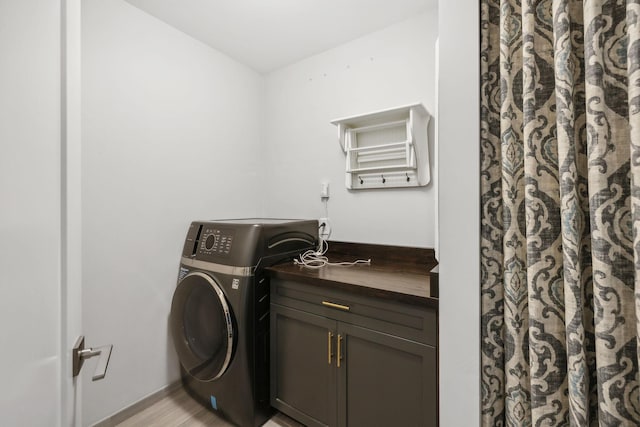 laundry area with washer / clothes dryer, light wood-type flooring, and cabinet space