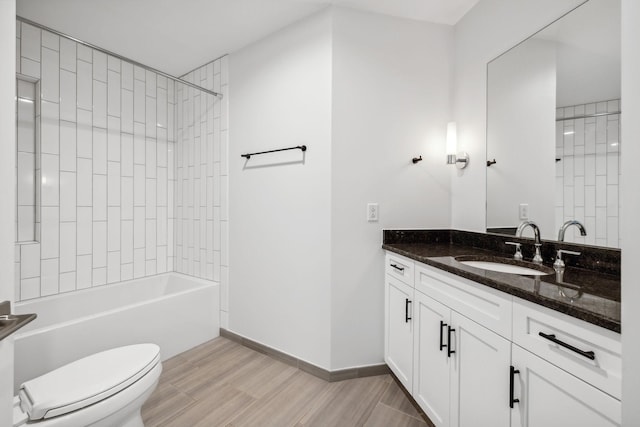 full bath featuring shower / bathtub combination, toilet, vanity, wood finished floors, and baseboards