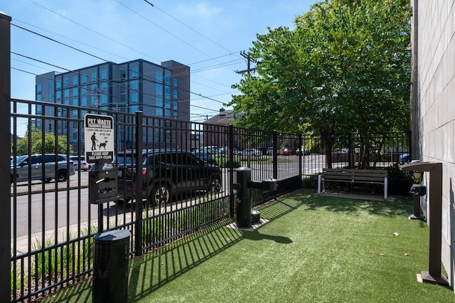 view of gate featuring fence and a lawn