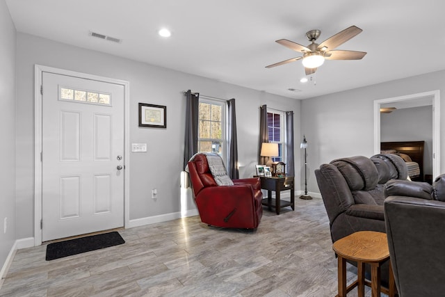 living room with ceiling fan, recessed lighting, visible vents, baseboards, and light wood-type flooring