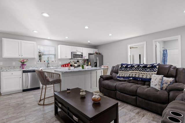 living area with light wood-style flooring and recessed lighting