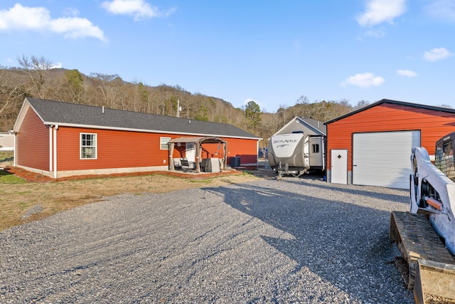 view of front of house with a garage, central AC, and an outdoor structure