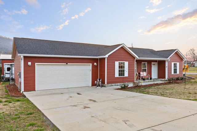 ranch-style house featuring a garage, a shingled roof, a porch, and concrete driveway