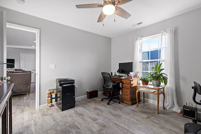 office area featuring light wood finished floors, baseboards, visible vents, and a ceiling fan