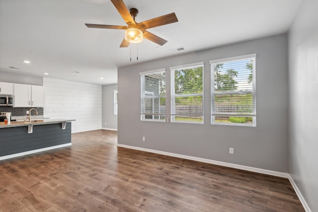 unfurnished living room featuring baseboards, visible vents, dark wood-style flooring, and recessed lighting