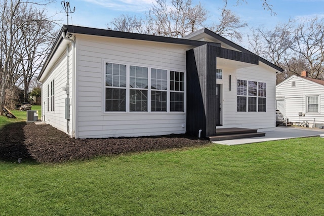 back of house with a patio, a lawn, and central air condition unit