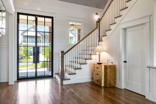 entryway featuring dark wood-style floors, stairway, and a healthy amount of sunlight