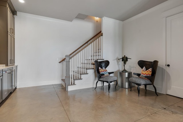 living area featuring concrete flooring, recessed lighting, stairway, and baseboards