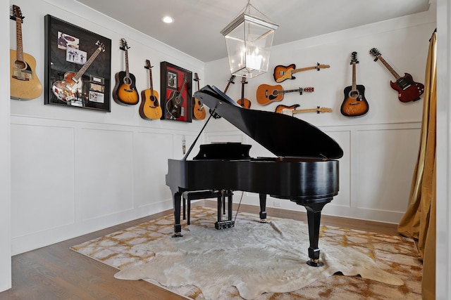 sitting room with a notable chandelier, recessed lighting, a decorative wall, wood finished floors, and wainscoting