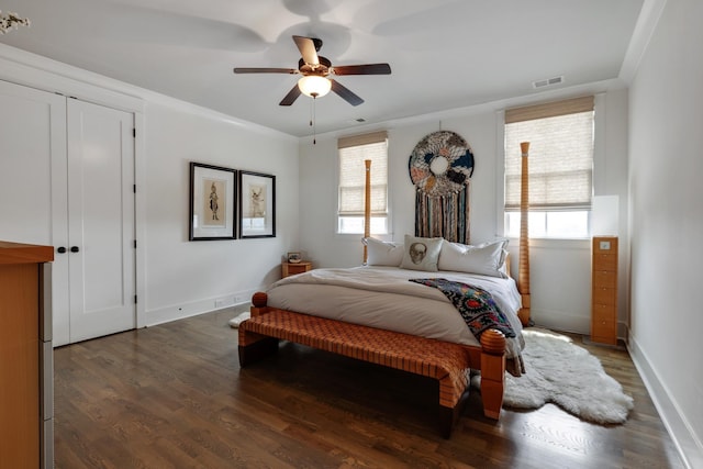 bedroom featuring baseboards, multiple windows, visible vents, and dark wood finished floors