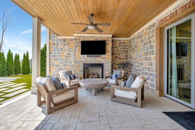 view of patio featuring a ceiling fan and an outdoor stone fireplace