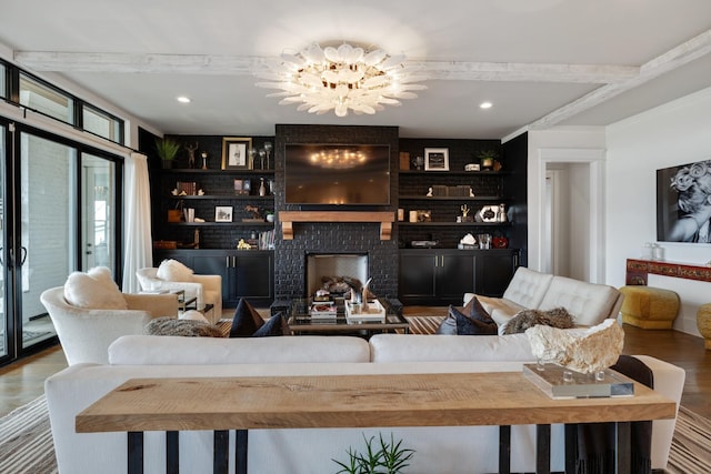 living room with recessed lighting, a brick fireplace, wood finished floors, and an inviting chandelier