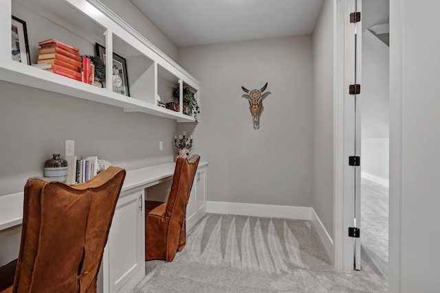 office with light colored carpet, built in study area, and baseboards