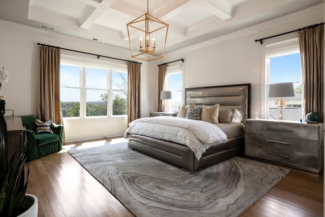 bedroom featuring multiple windows, visible vents, coffered ceiling, and wood finished floors