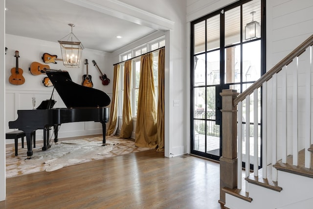 foyer entrance featuring a wealth of natural light, stairway, and wood finished floors