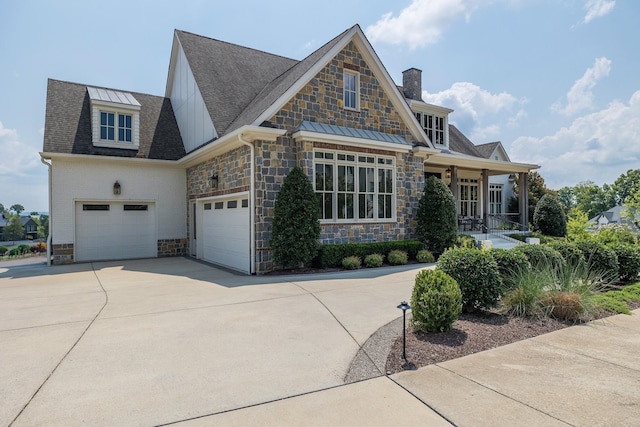 view of front of home featuring a garage, stone siding, a porch, and driveway