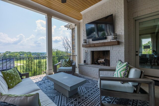 balcony featuring ceiling fan and an outdoor brick fireplace