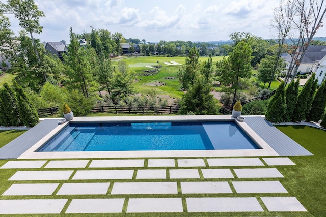 pool featuring a lawn, a patio area, and fence