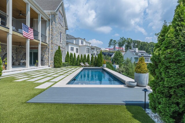 pool featuring a residential view, a lawn, a ceiling fan, and a patio