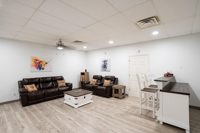 living area with light wood finished floors, visible vents, and baseboards