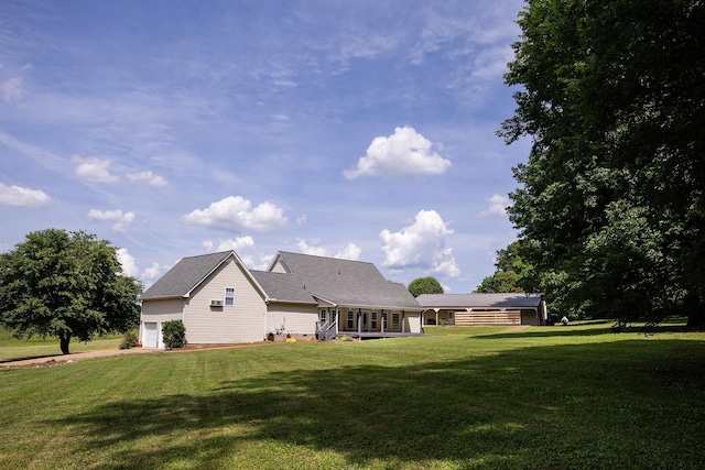 rear view of house featuring a garage and a lawn